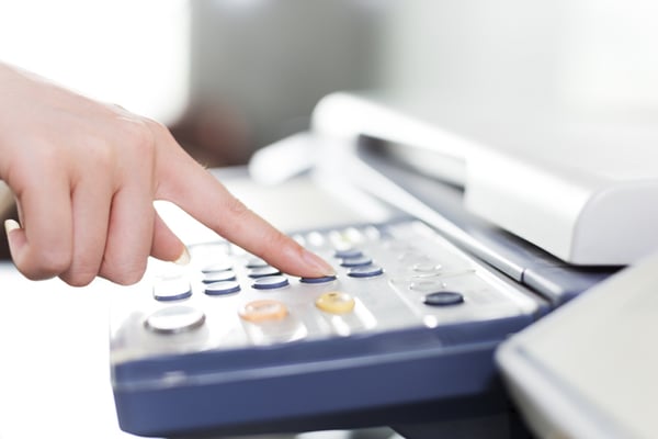 A worker start to scan documents to email by pushing a button on the copier