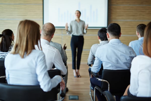 Employees watch a presentation on a smart white board