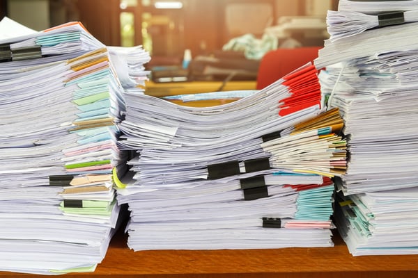 Many types of paper for printing sitting on a desk. 