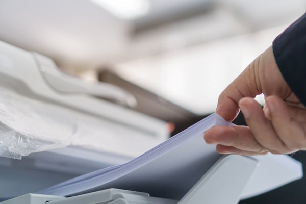 An employee uses one of many types of paper for printing.